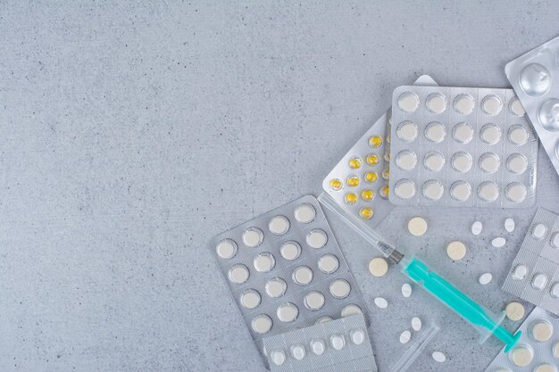 Assortiments de médicaments et seringue vide sur une surface en marbre