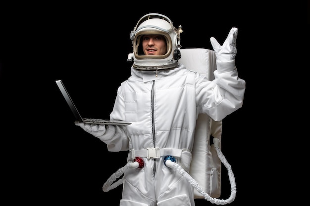 Photo gratuite astronaute jour astronaute en combinaison spatiale blanche costume casque de verre ouvert tenant la main levée de l'ordinateur