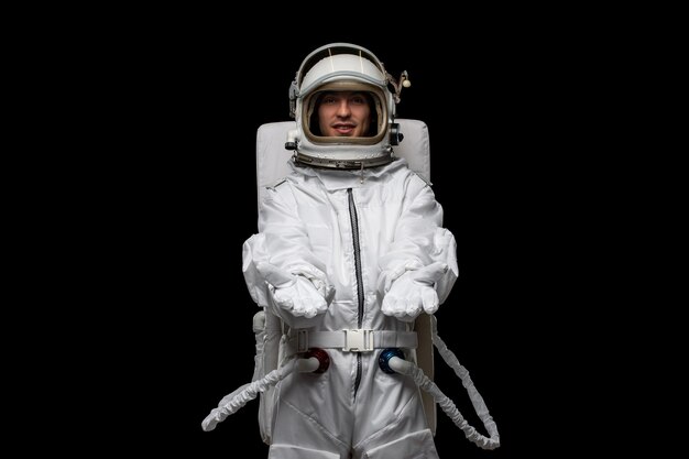 Astronaute de jour de l'astronaute en combinaison spatiale blanche avec les mains ouvertes accueillant un casque en verre ouvert