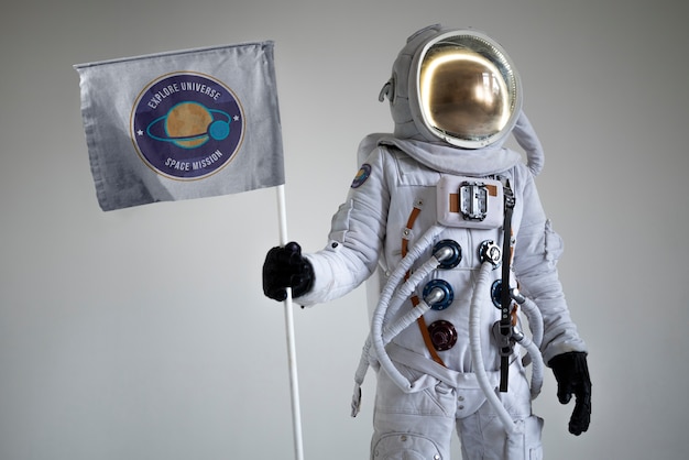 Photo gratuite astronaute masculin entièrement équipé tenant un drapeau