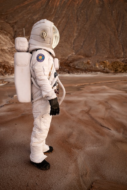 Photo gratuite astronaute masculin regardant autour pendant une mission spatiale sur une autre planète