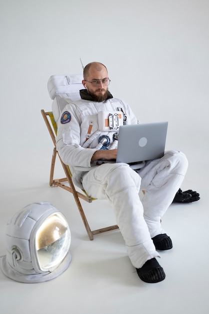 Astronaute Masculin Travaillant Sur Son Ordinateur Portable En Combinaison Spatiale