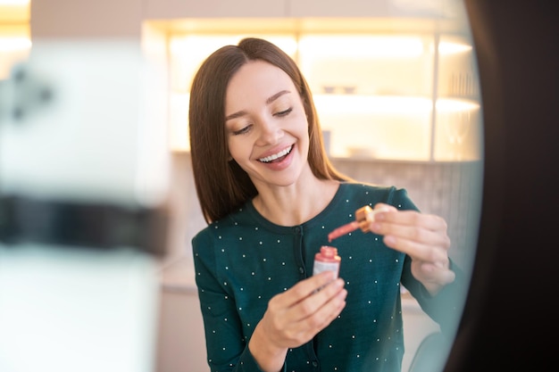 Atelier beauté. Jeune esthéticienne démontrant de nouveaux produits de beauté lors d'un atelier en ligne