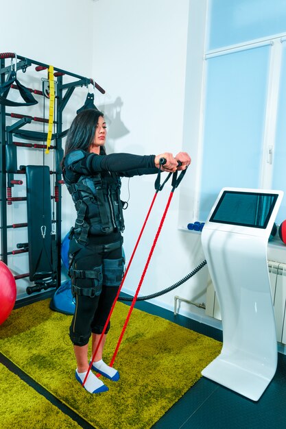 L'athlète féminine faisant de l'exercice dans un studio de fitness