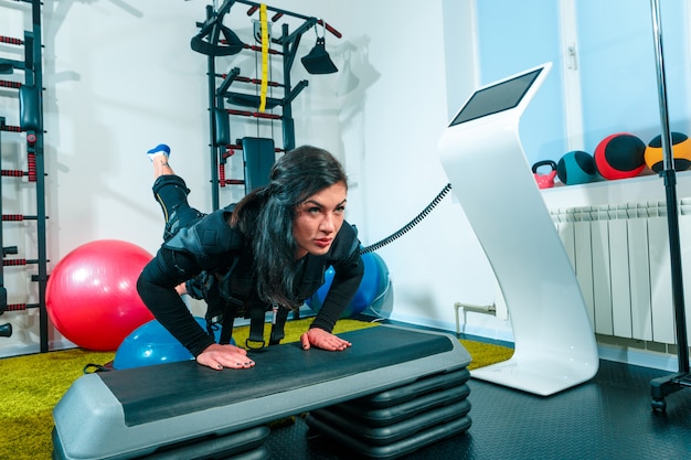 Photo gratuite l'athlète féminine faisant ils exercent dans un studio de remise en forme ems