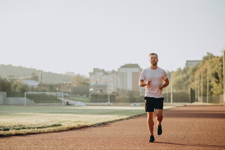 Photo gratuit athlète homme jogging au stade le matin