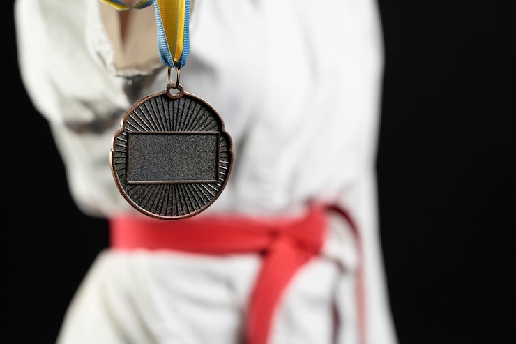Photo gratuit athlète de karaté avec ceinture rouge et médaille