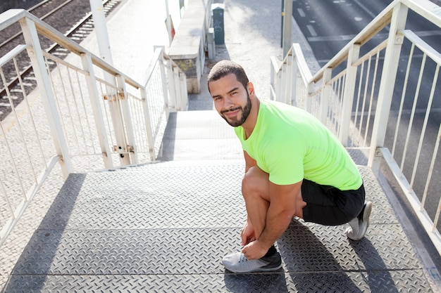 Photo gratuite un athlète sportif attachant des lacets sur des baskets