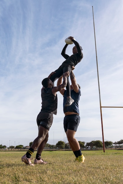 Photo gratuite athlètes masculins jouant au rugby sur le terrain