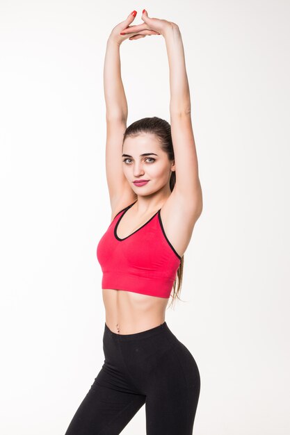 Athletic woman stretching - isolé sur un mur blanc