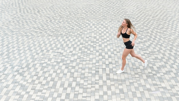 Athlétique fille courir sur le sol