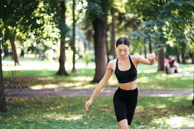 Athlétique jeune femme faisant du yoga dans le parc le matin