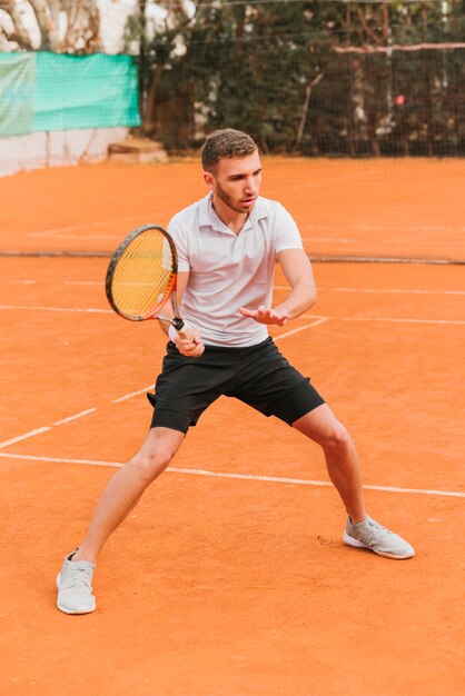 Athlétique jeune garçon jouant au tennis