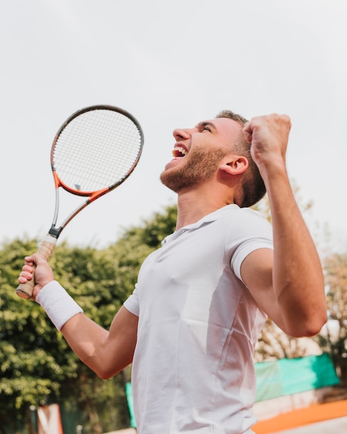 Photo gratuite athlétique jeune garçon remportant un match de tennis