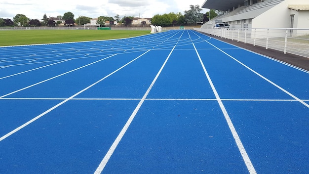Athlétisme exécutant une ligne blanche de piste bleue dans un stade de sport