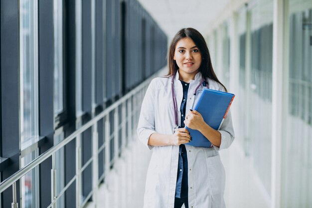 Attractive femme médecin debout avec des documents à l'hôpital