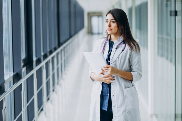 Attractive femme médecin debout avec des documents à l'hôpital