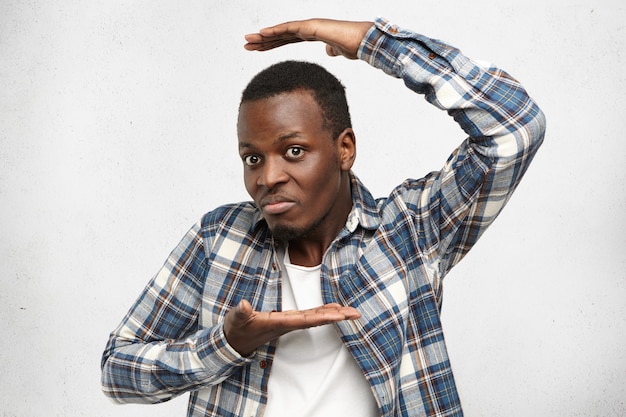 Attractive homme afro-américain en chemise à carreaux gesticulant