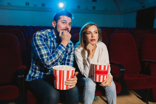 Attractive jeune couple regardant un film dans une salle de cinéma