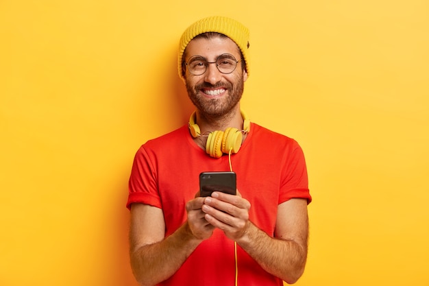 Attrayant mec gai avec des poils, porte un chapeau brillant et un t-shirt rouge