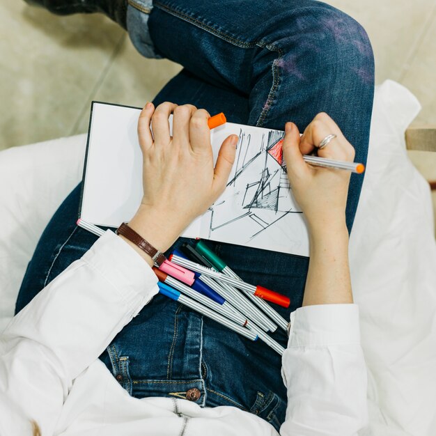 D&#39;au-dessus de la femme dessinant avec des doublures fines