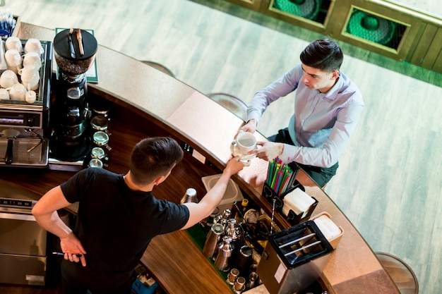 Photo gratuite d'au-dessus de l'homme donnant un verre au client