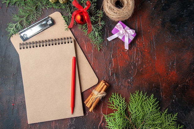 Au-dessus de la vue des branches de sapin cadeau de limes à la cannelle et cahier sur fond sombre