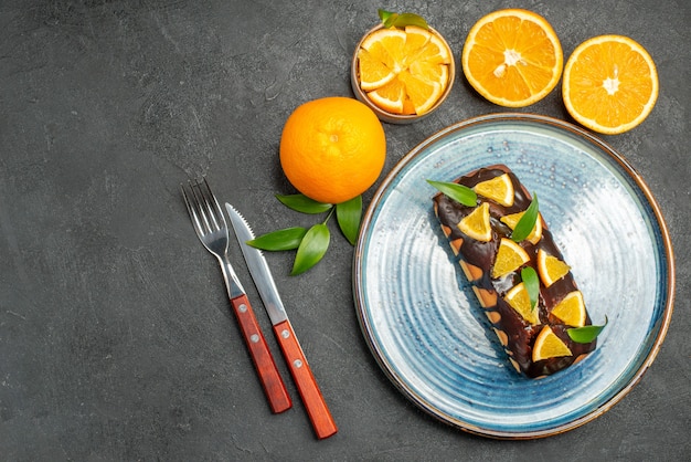 Au-dessus de la vue d'ensemble de gâteaux savoureux d'oranges entières et coupées jaune sur table sombre