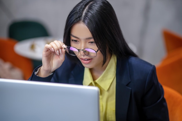 Au travail. Femme d'affaires asiatique au bureau travaillant sur un ordinateur portable