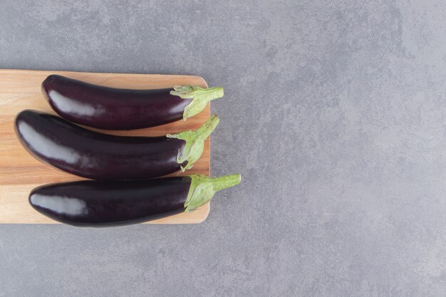 Aubergine dentelée sur la planche, sur la surface en marbre