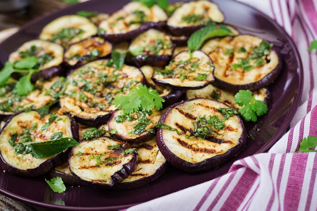 Aubergine grillée avec sauce balsamique, ail, coriandre et menthe. Nourriture végétalienne. Aubergine grillée.