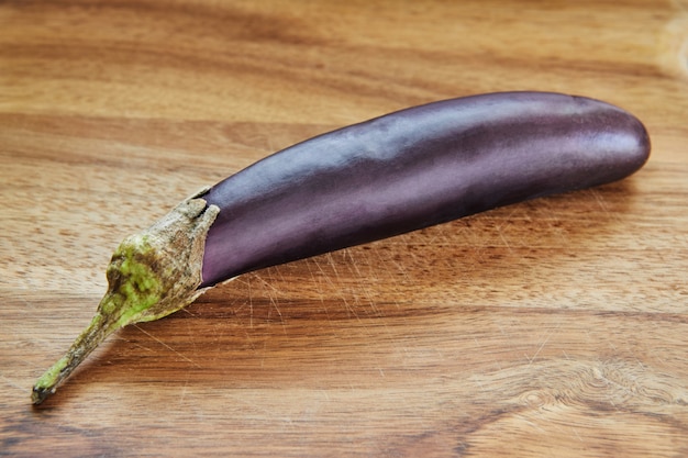 L'aubergine Japonaise Se Trouve Sur Une Planche De Bois Dans La Cuisine. Photo Premium