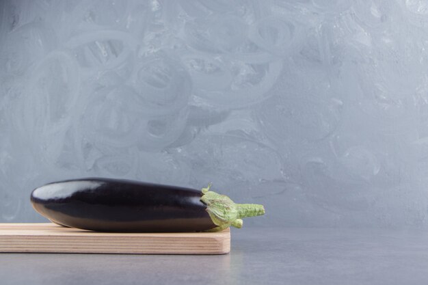 Aubergine Toothsome sur la planche, sur la surface en marbre