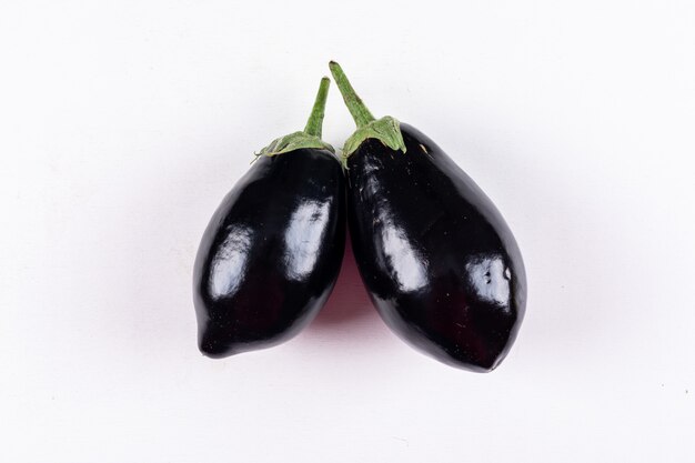 Aubergines côte à côte sur fond blanc. vue de dessus.