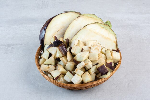 Aubergines crues hachées dans un bol en bois. Photo de haute qualité