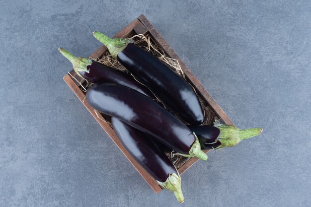 Aubergines fraîches mûres dans une boîte en bois.