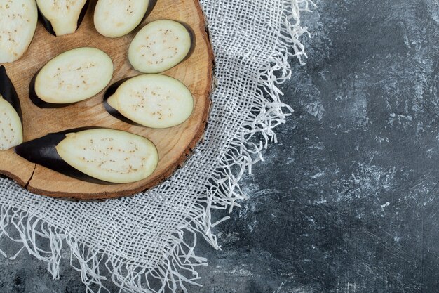 Aubergines fraîches tranchées sur planche de bois