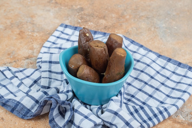 Aubergines marinées farcies dans un bol bleu