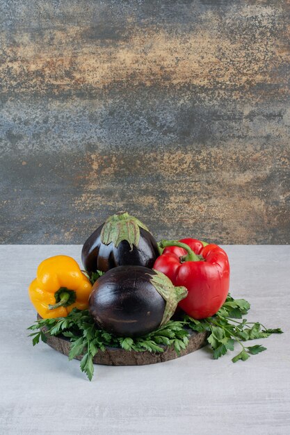 Aubergines, poivrons et persil sur pièce en bois. Photo de haute qualité