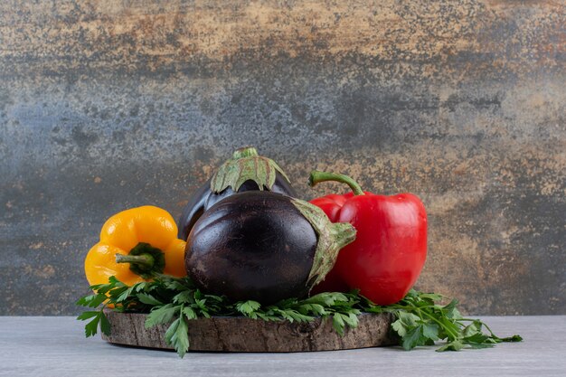 Aubergines, poivrons et persil sur pièce en bois. Photo de haute qualité