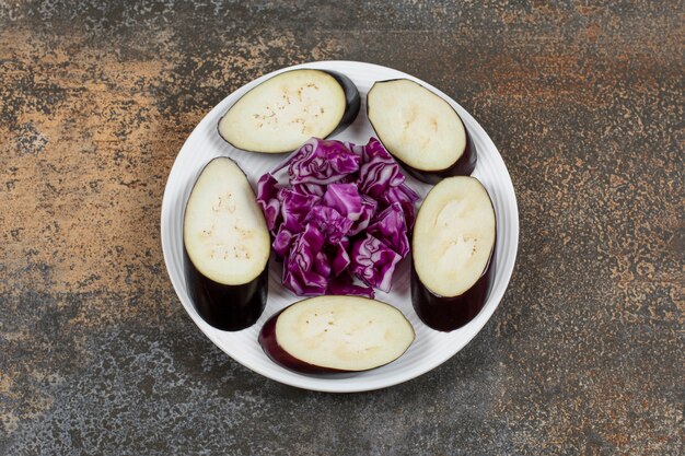 Aubergines en tranches et chou rouge finement haché, sur la surface du marbre