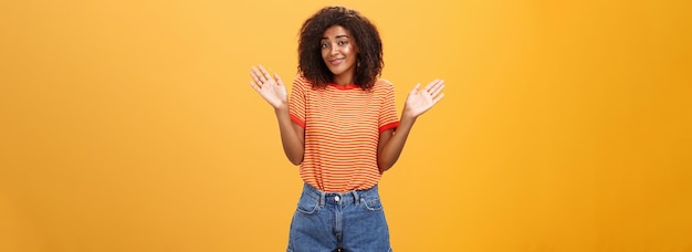 Photo gratuite aucune idée ne se soucie pas négligent et indifférent calme heureuse femme afro-américaine avec les cheveux bouclés dans