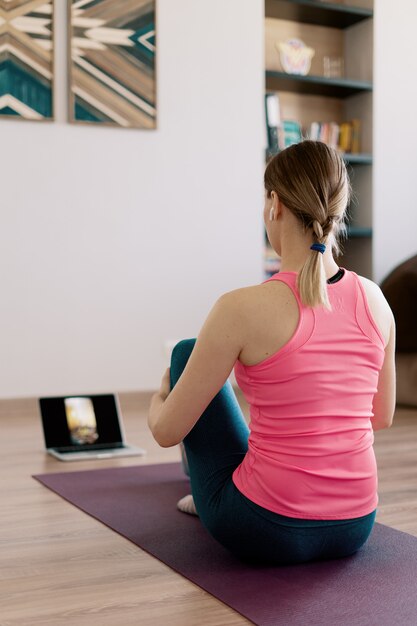 Authentique femme pratiquant le yoga à la maison