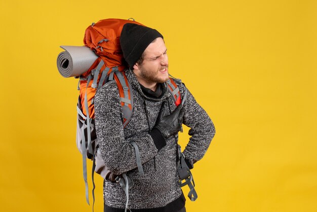 auto-stoppeur masculin avec des gants en cuir et un sac à dos tenant le coeur avec la douleur