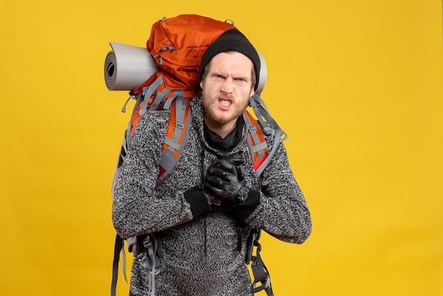 auto-stoppeur masculin nerveux avec des gants en cuir et un sac à dos montrant des coups de poing