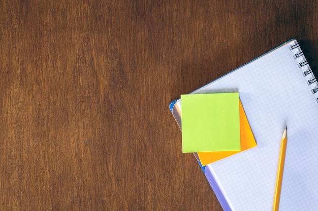 Photo gratuite des autocollants de papier et un crayon sur une table de bureau en bois