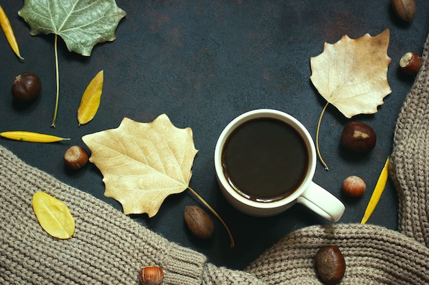 Automne, feuilles d’automne, tasse de café chaud à la vapeur et écharpe ou gilet chaud. Café du matin saisonnier, dimanche relaxant et concept nature morte.