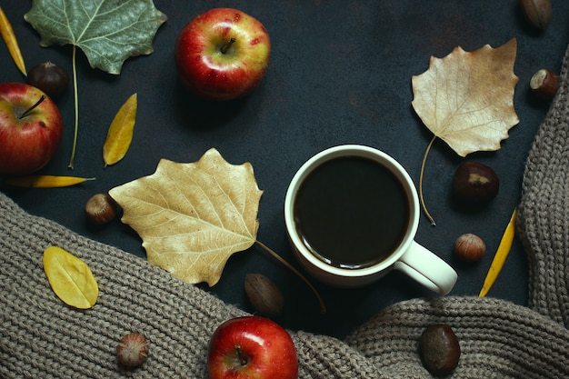 Automne, feuilles d’automne, tasse de café chaud à la vapeur et écharpe ou gilet chaud. Café du matin saisonnier, dimanche relaxant et concept nature morte.