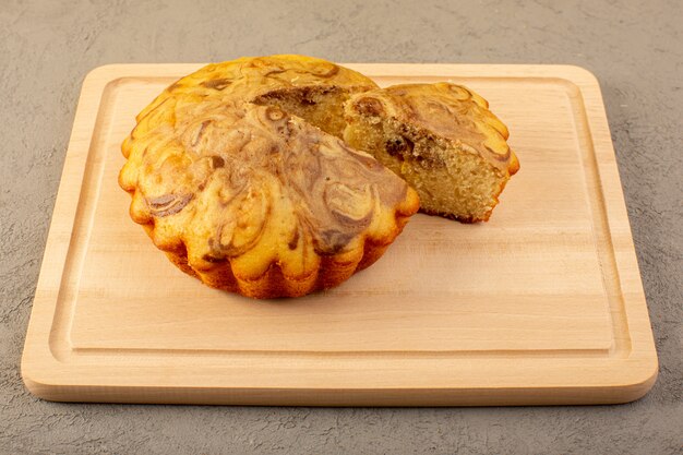 Un avant fermé vue gâteau sucré délicieux délicieux gâteau choco tranché sur le bureau carré de couleur crème