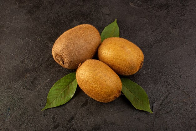 Un avant fermé vue kiwis bruns mûrs frais isolés juteux et fruits entiers avec des feuilles vertes